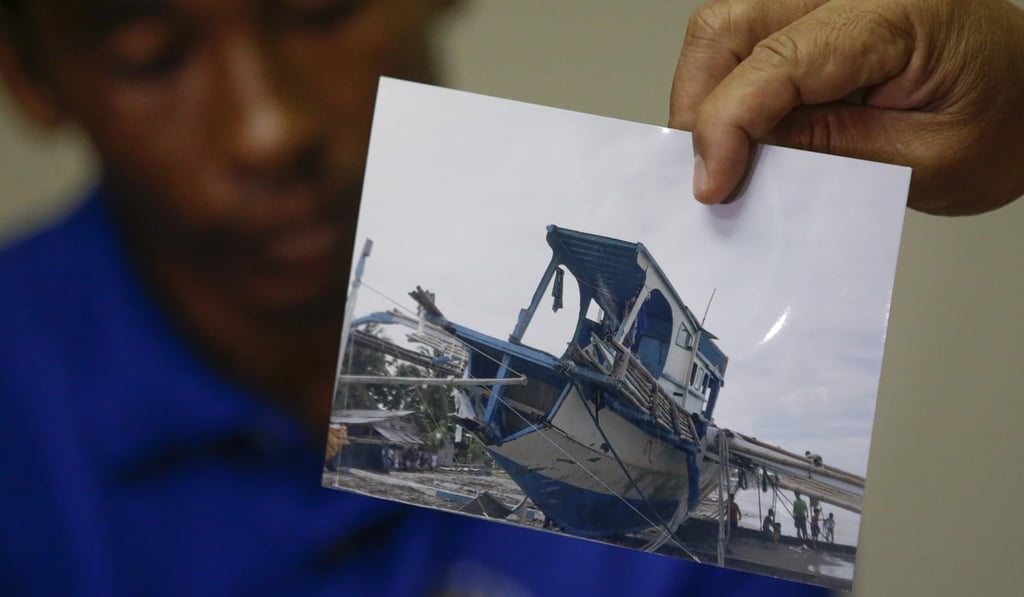 A photo of the damaged Filipino fishing vessel is shown by one of its crew during a press conference in Manila on June 17. Photo: AP