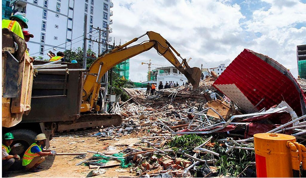 Rescuers use an excavator to clear debris after a building collapsed while under construction in Sihanoukville on June 22. Photo: AFP Rescuers use an excavator to clear debris after a building collapsed while under construction in Sihanoukville on June 22. Photo: AFP