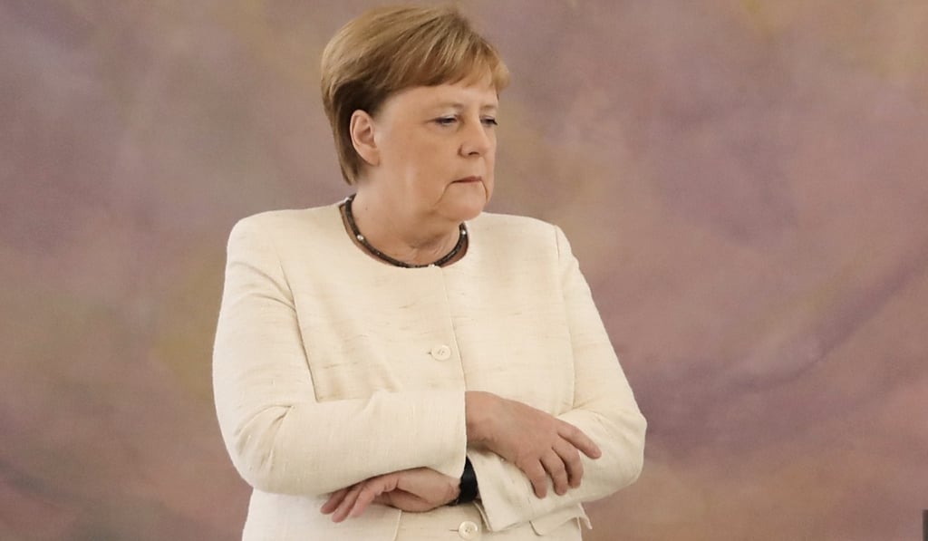 German Chancellor Angela Merkel folds her arms during a shaking spell at a ceremony in Berlin on Thursday. Photo: AFP German Chancellor Angela Merkel folds her arms during a shaking spell at a ceremony in Berlin on Thursday. Photo: AFP