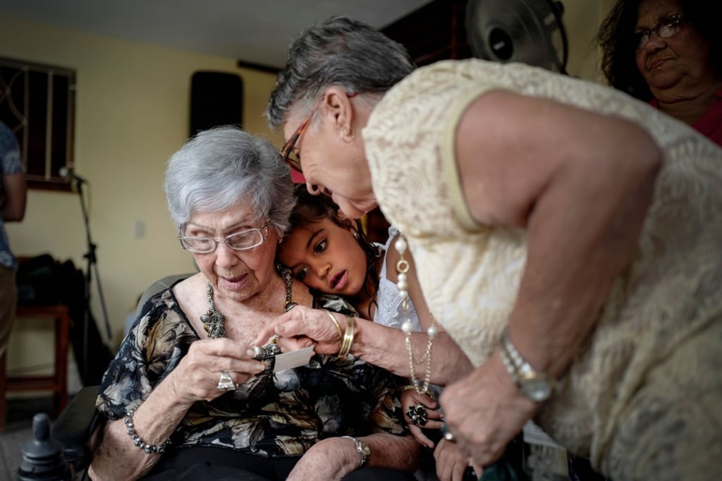 Delia Barroso (left) receives a present at her 102nd birthday party in Havana. Photo: AFP