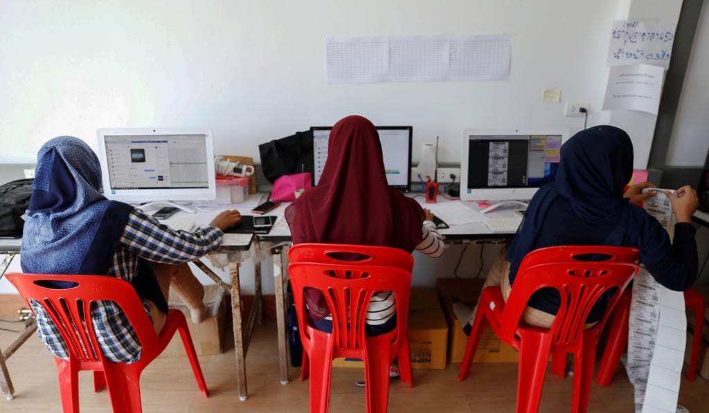 Workers receive online orders for Anurak Sareuthai. Photo: Reuters