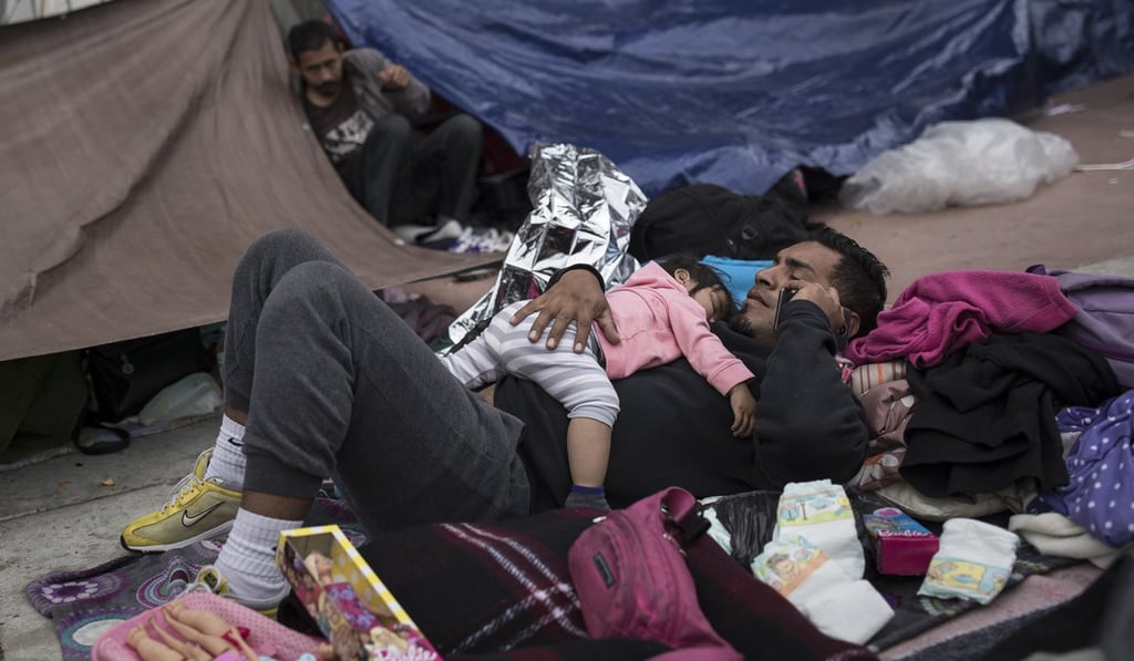 A Central American migrant father with his child at a shelter in Tijuana. Photo: AP