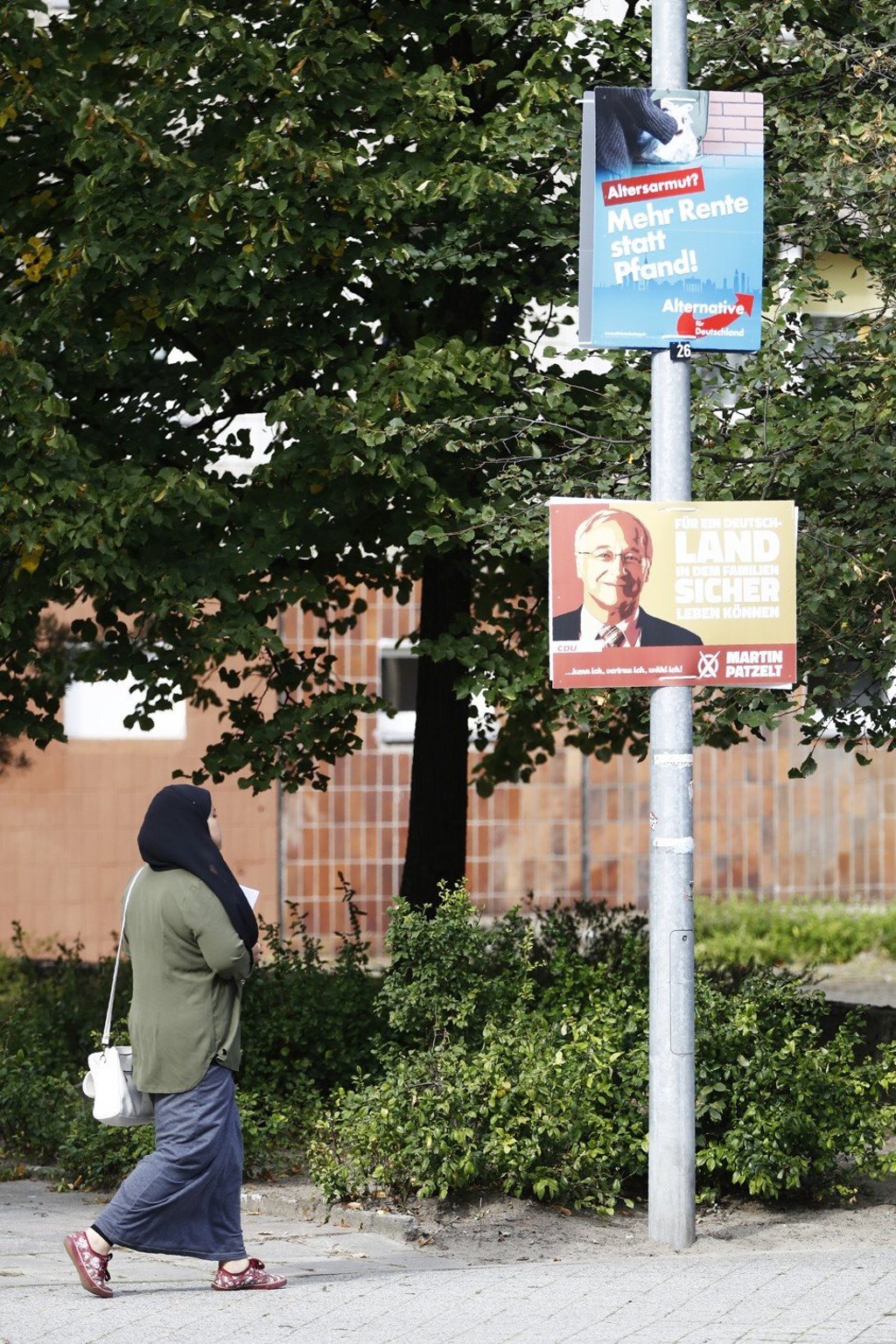 A woman walks past election placards of the anti-Islam, anti-immigration AfD (Alternative für Deutschland/Alternative for Germany) party and for Christian Democratic Union candidate Martin Patzelt in eastern Germany. Photo: Odd Andersen/AFP