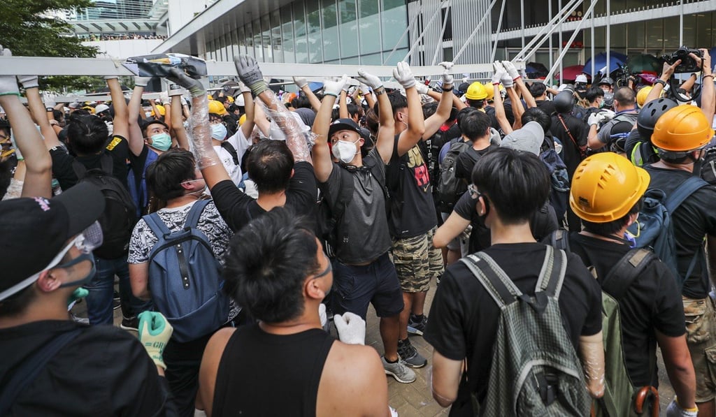 Protesters pull down metal bars in an attempt to storm the Legislative Council complex in Tamar. Photo: Sam Tsang Protesters pull down metal bars in an attempt to storm the Legislative Council complex in Tamar. Photo: Sam Tsang