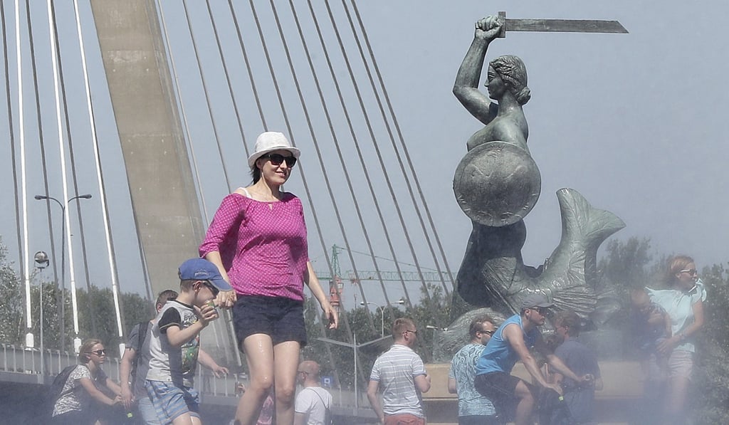 People cool off by the Vistula River during a heatwave in Warsaw, Poland. Photo: AP