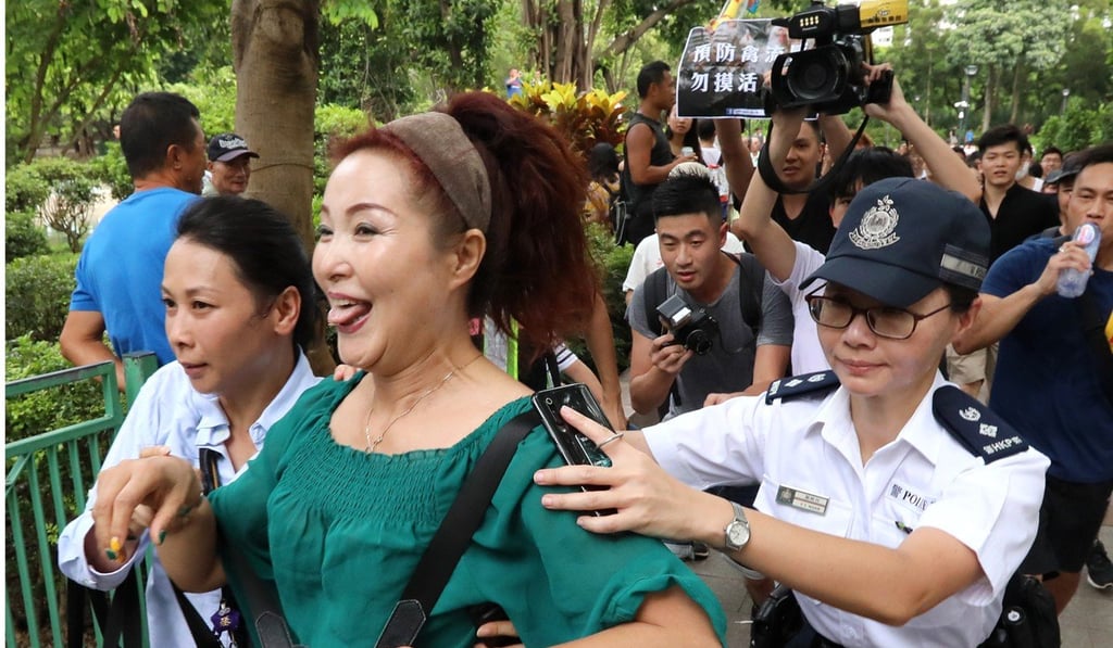 A dama is escorted away from the park by police. Photo: Felix Wong