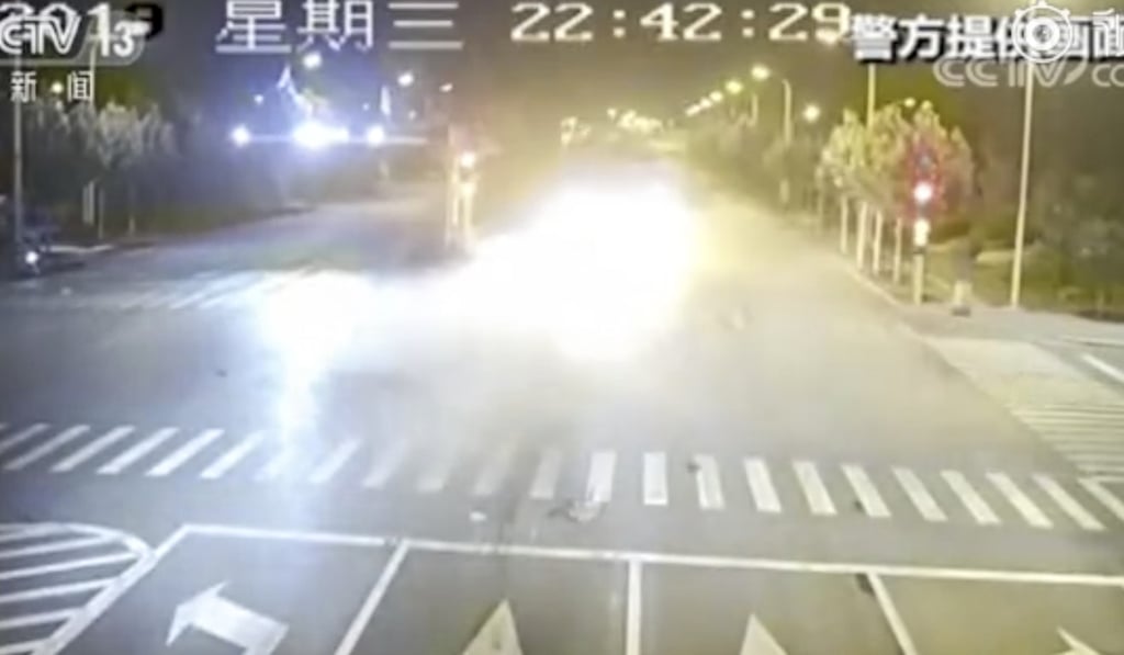 The BMW bursts into flames after being shoved across the intersection. Photo: Weibo