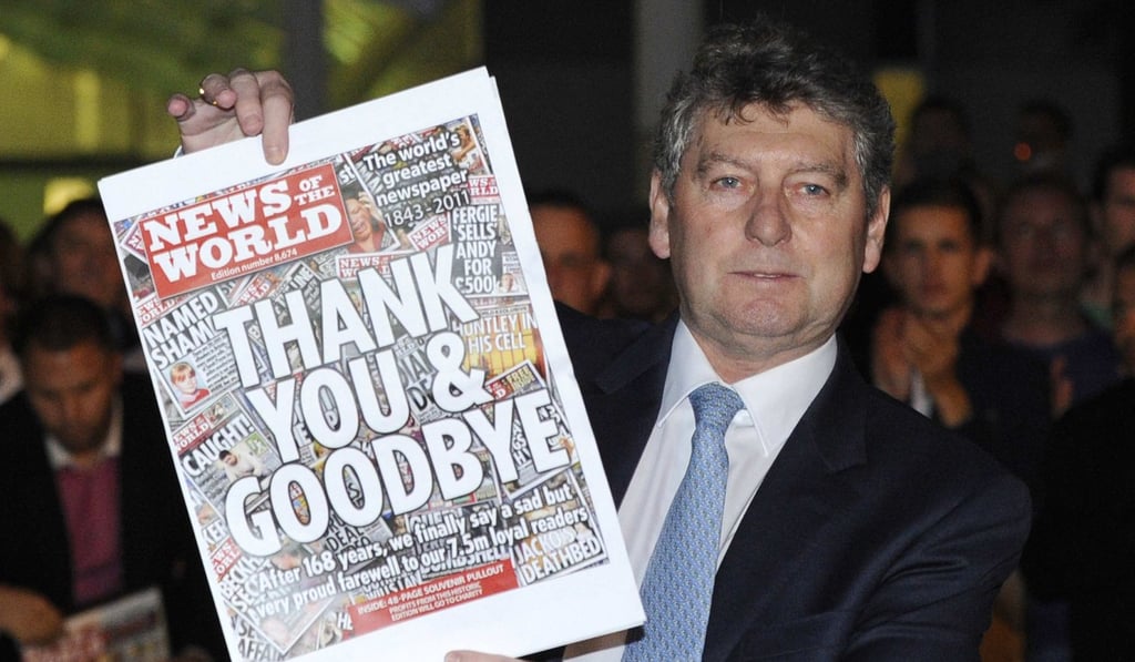 Colin Myler, then-editor of the News of The World, with the final edition of the paper in 2011 after its closure in the wake of the phone hacking scandal. Photo: Reuters