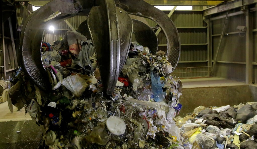 Garbage is dropped from a grappler to be fed into a combustion chamber and incinerated at a garbage facility. Photo: Reuters