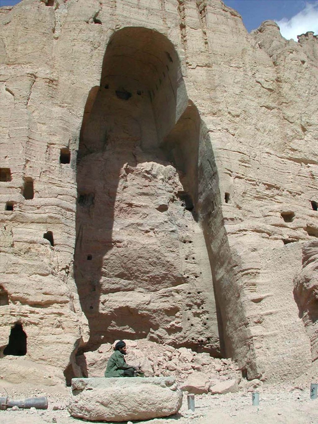 A Taliban fighter sitting on a piece of rubble in front of one of the demolished Buddha statues in the central Afghan province of Bamiyan in 2001. Photo: Reuters