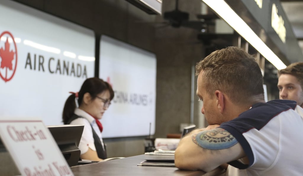 Andrew Szucs, right, who was on the Air Canada flight that made an emergency landing, waits for help at the Air Canada desk at Honolulu's international airport. Photo: AP