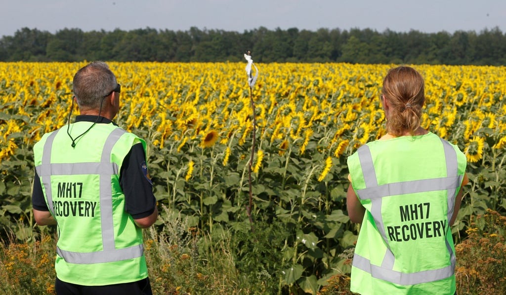Forensic experts carry out recovery work at the site of the downed airliner. Photo: Reuters