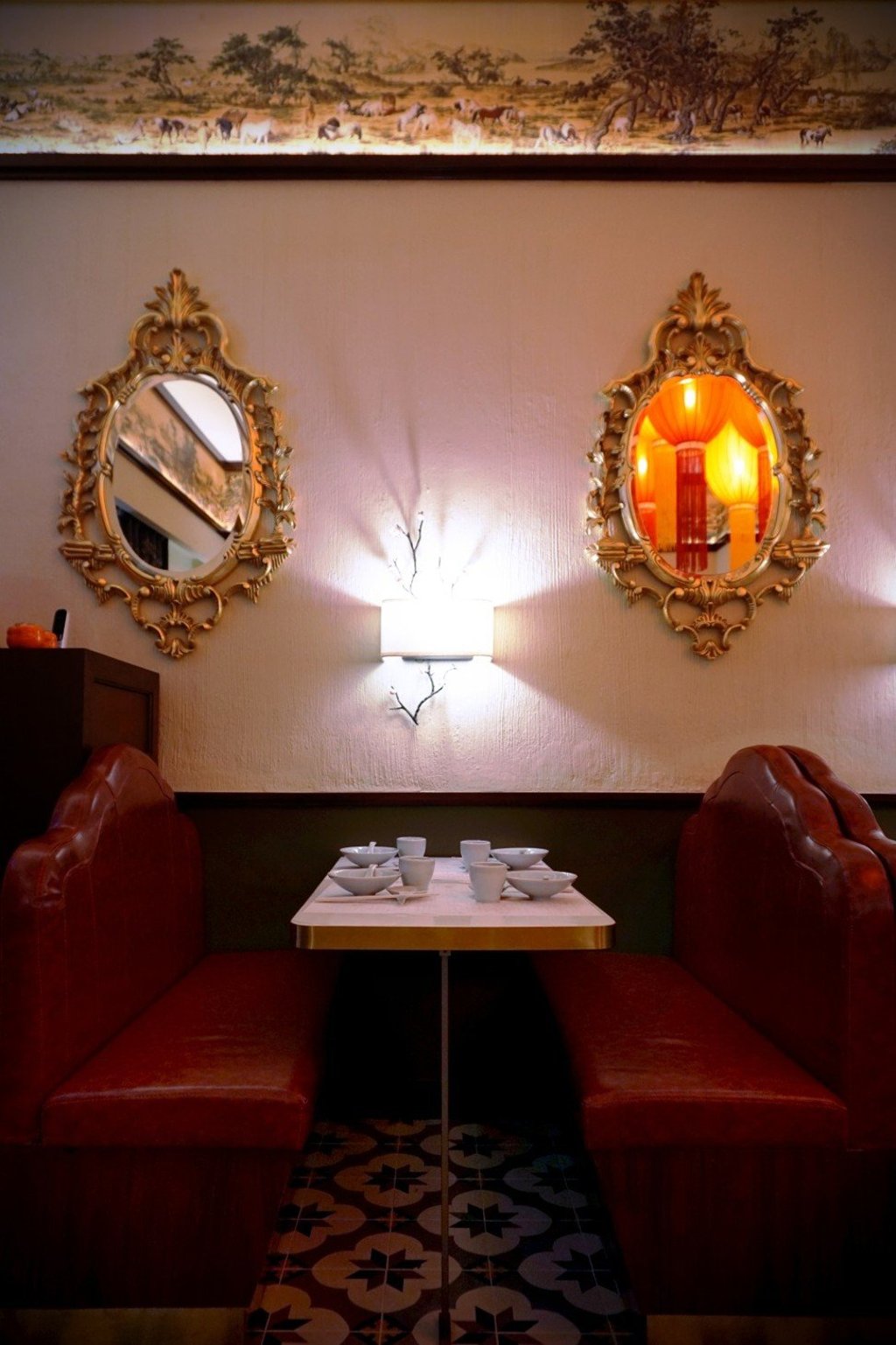 The walls are lined with booth seats and a mosaic tiled floor.