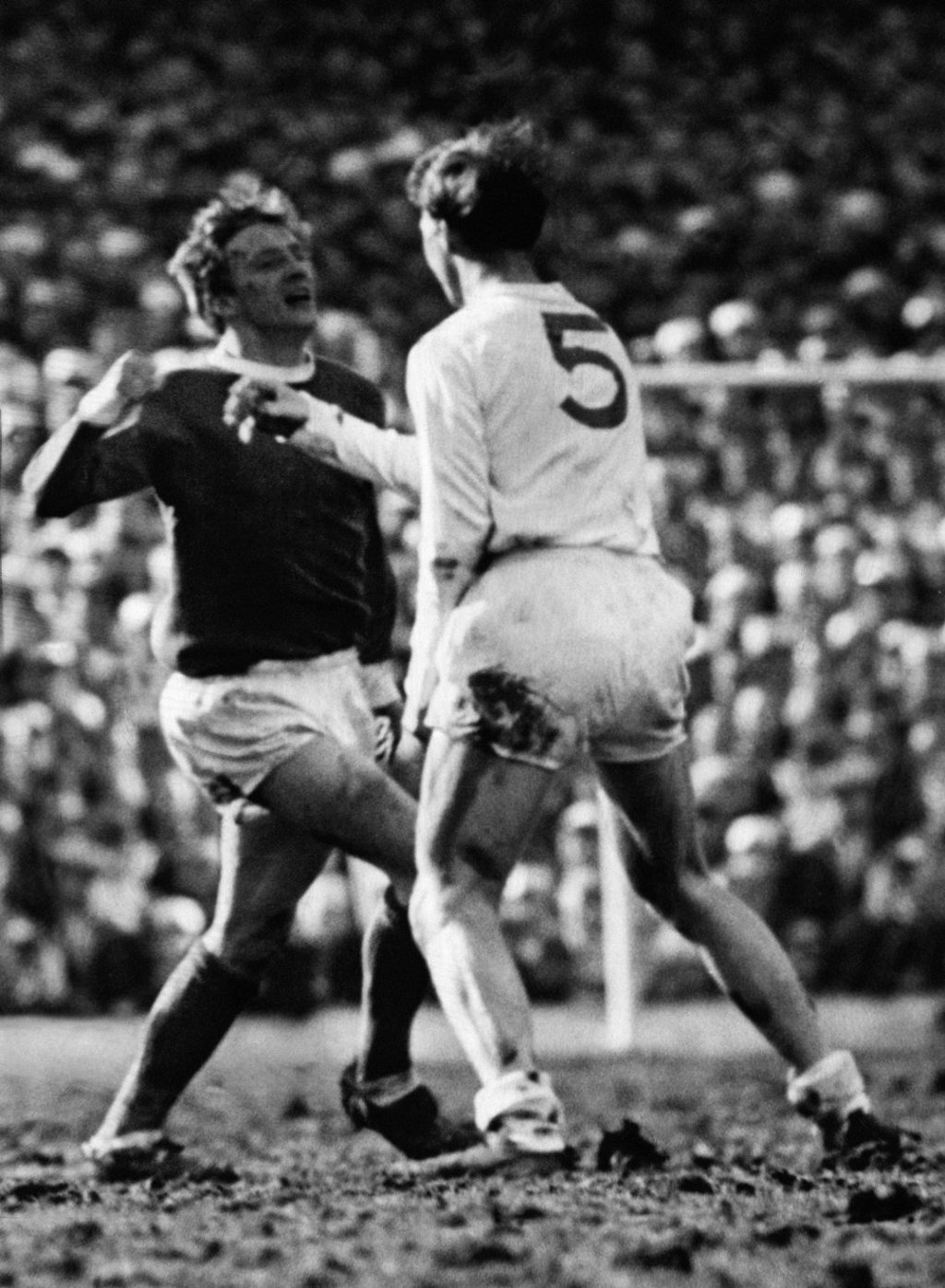 Denis Law raises his fist to Jackie Charlton as Man United and Leeds clash in March 1965. Photo: Alamy
