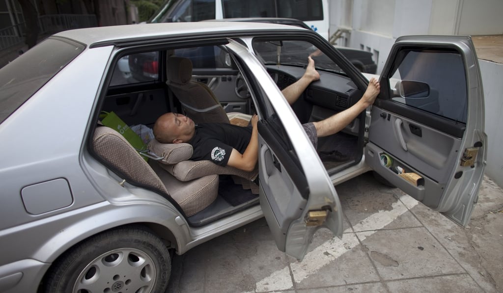 A man sleeps in a car in Beijing, China, in September 2011. Photo: AP