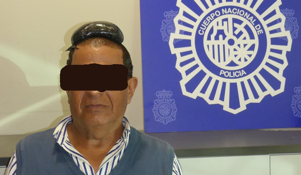 A man poses with a drug package on his head, which he had hidden under a toupee, in a picture released on Tuesday. Photo: Spanish National Police via Reuters