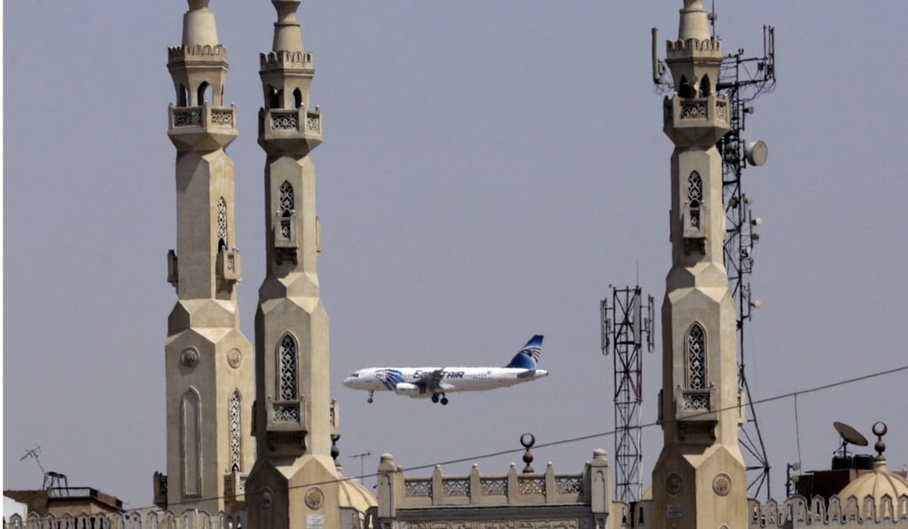 An EgyptAir plane flies past minarets of a mosque as it approaches Cairo International Airport. File photo: AP