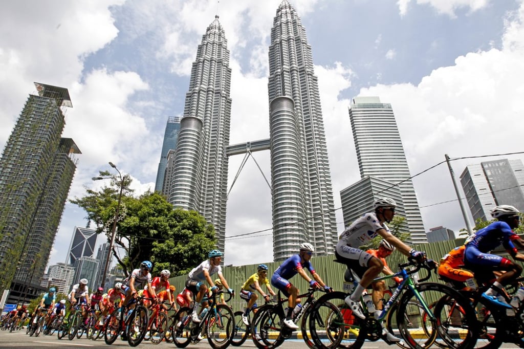 Cyclists ride past the Petronas Towers in Kuala Lumpur in May 2018. Photo: AP