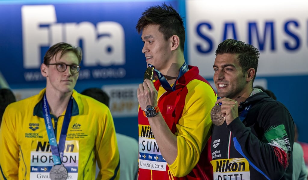 Second placed Mack Horton of Australia keeps his distance from winner Sun Yang of China while they pose with their medals on Sunday. Photo: EPA Second placed Mack Horton of Australia keeps his distance from winner Sun Yang of China while they pose with their medals on Sunday. Photo: EPA