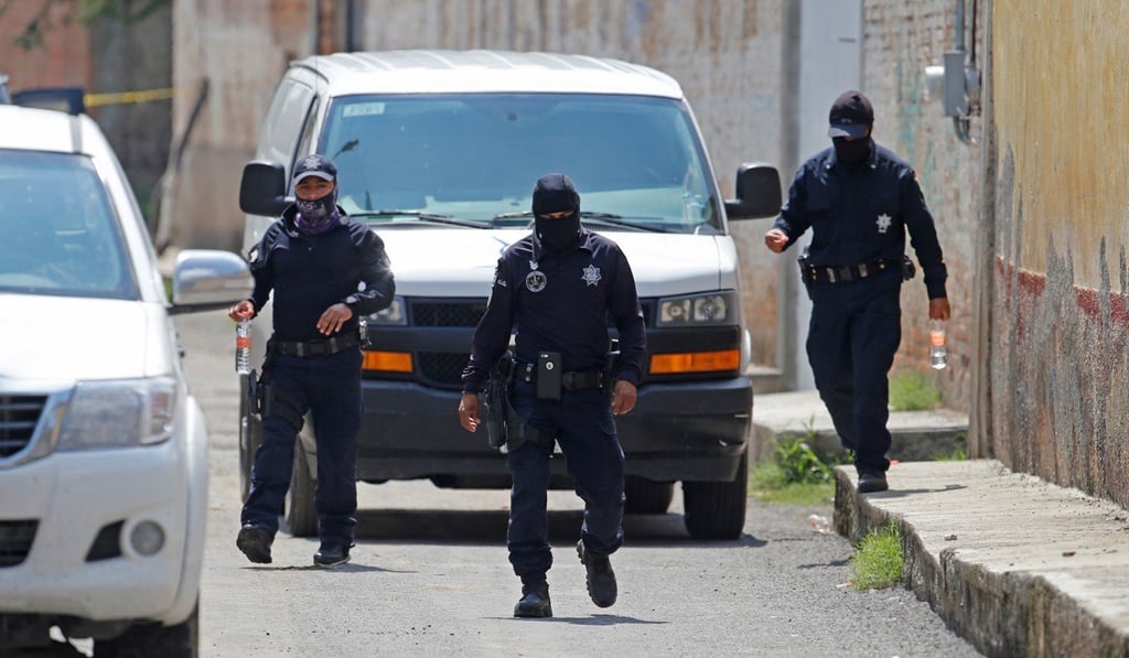 Police guard an estate where the bodies of three men, a grave with four corpses and nine plastic bags with human remains were found, in Tonala, Jalisco in July. Photo: EPA