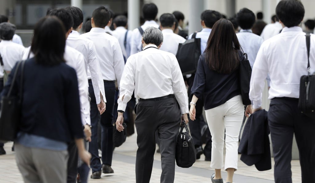 Morning commuters walk along a street in Tokyo. Photo: Bloomberg Morning commuters walk along a street in Tokyo. Photo: Bloomberg
