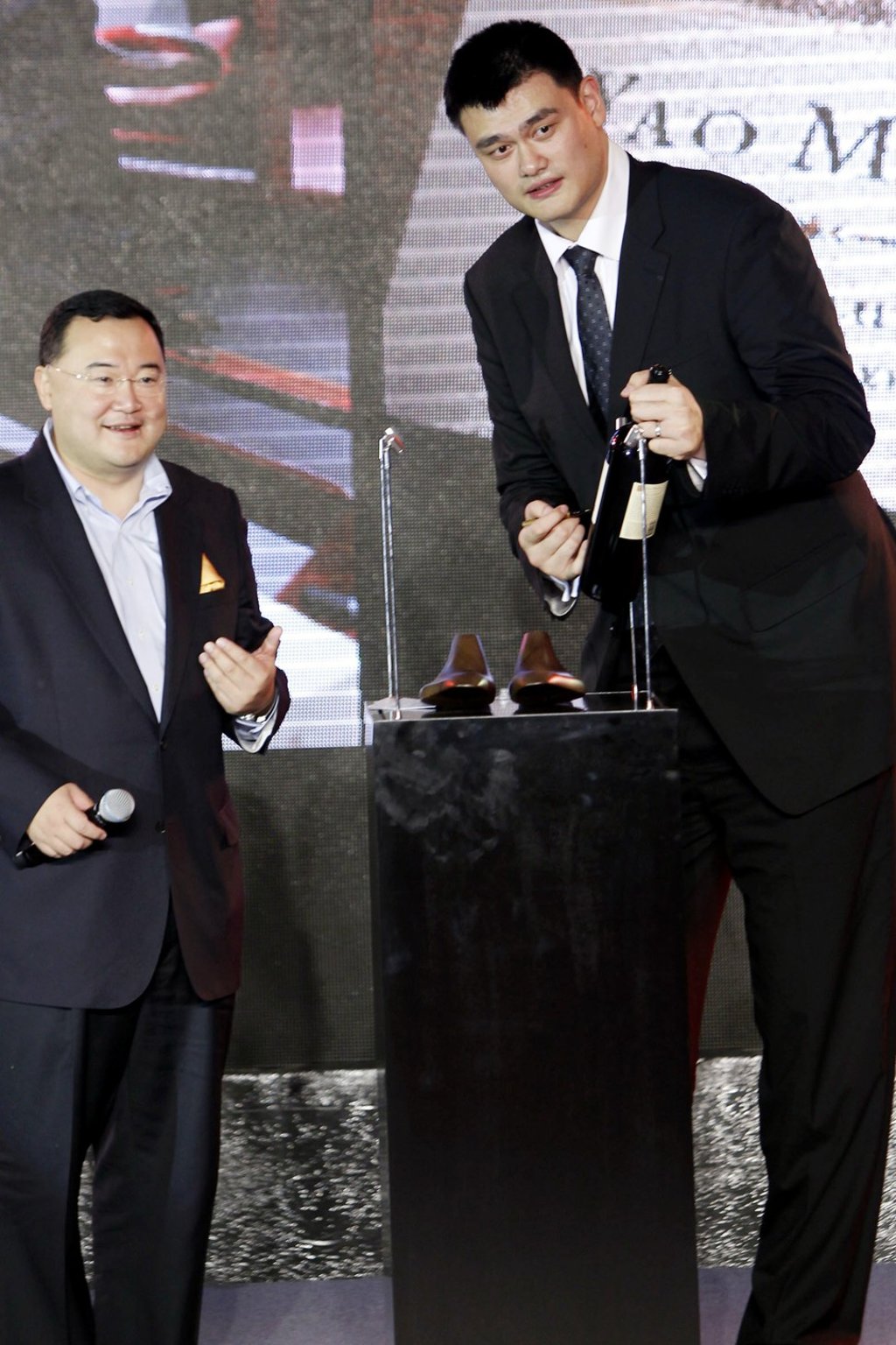 Retired Chinese basketball superstar Yao Ming (right) signing a bottle of Yao Ming sauvignon cabernet bought by Bruno Wu, Co-Founder and Chairman of Sun Media Investment Holdings Limited, at a charity auction for the Special Olympics in Shanghai on 27 November 2011. Photo: SCMP
