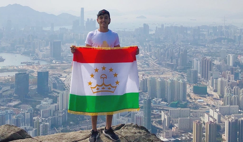 Rustam Juraev holding the Tajikistan flag to commemorate his hike to the “suicide cliff” on Kowloon Peak. Photo: Nurdaulet Kemel