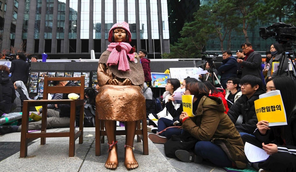 South Korean protesters sit near a statue of a girl symbolising former “comfort women” forced into sexual slavery, at a demonstration in front of the Japanese embassy in Seoul in November 2018. Photo: AFP