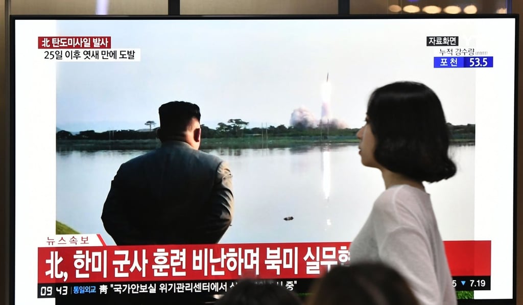 A woman walks past a television news screen in Seoul on Wednesday showing file footage of North Korean leader Kim Jong-un watching a missile launch. Photo: AFP