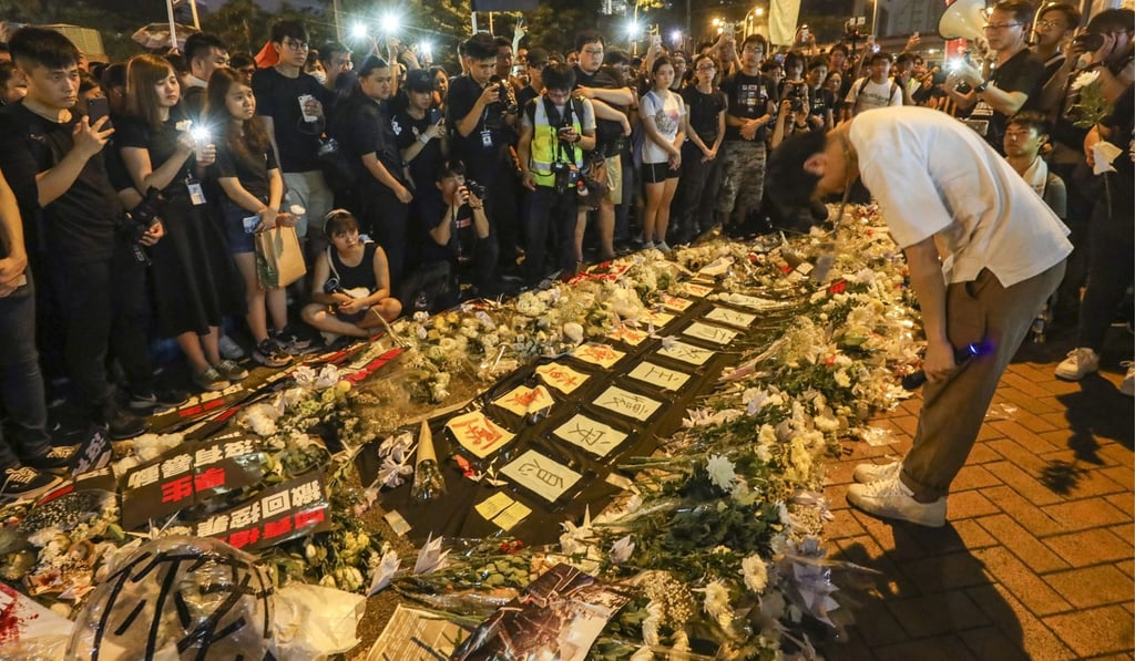 Lawmaker Roy Kwong Chun-yu bows before bouquets laid outside Pacific Place in Admiralty on June 17 to pay tribute to a man who fell to his death while protesting against the extradition bill. Photo: Dickson Lee
