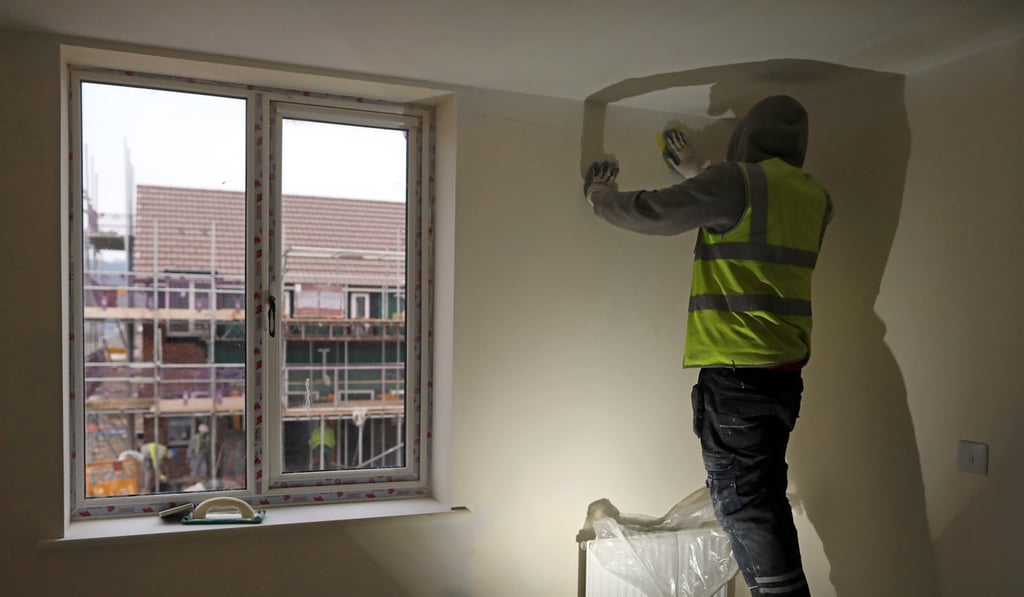 A workman sands a wall inside a house at a Persimmon residential property construction site in Weston-Super-Mare, UK, on January 26, 2017. Photo: Bloomberg