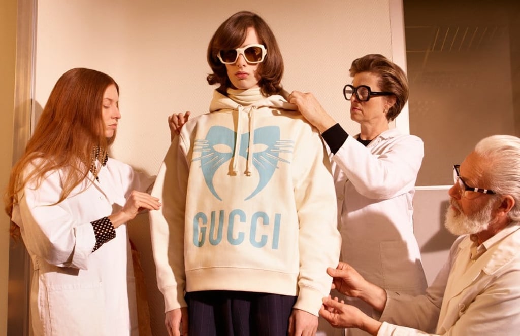 A hooded sweatshirt with a pale blue carnival cat mask motif from the Gucci Manifesto clothing collection A hooded sweatshirt with a pale blue carnival cat mask motif from the Gucci Manifesto clothing collection