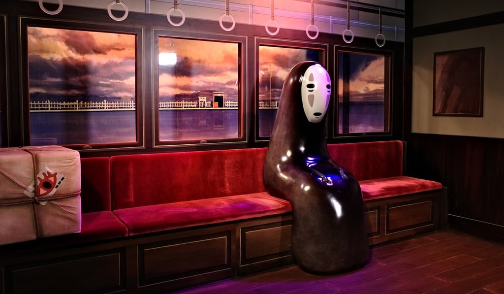 An installation of a scene from Spirited Away featuring the spirit No-man sitting on a train at sea. Photo: Oasis Li