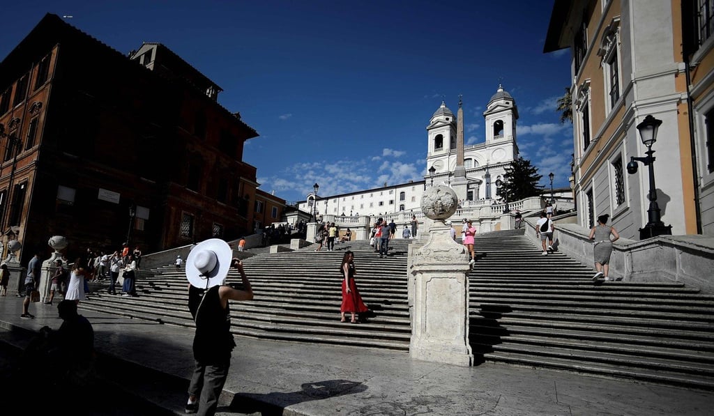 Tourists pose for a picture by the iconic Spanish Steps in Rome. Photo: AFP