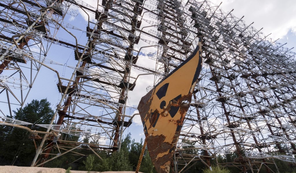 A rusty radioactivity warning sign sits beneath an inter-ballistic early warning radar system in the Chernobyl exclusion zone. Photo: Bloomberg