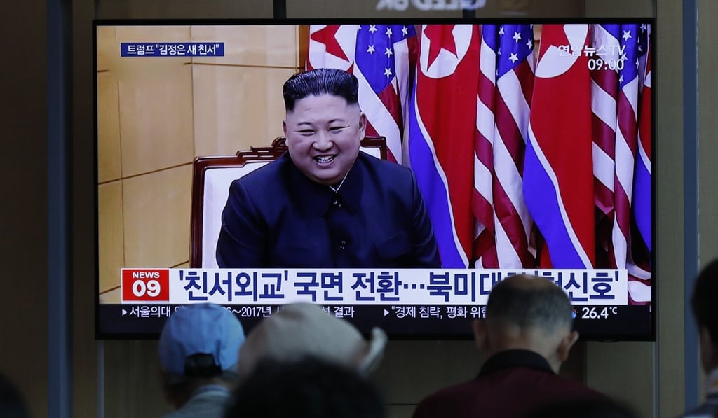People watch a TV news programme reporting on the projectiles. Photo: AP