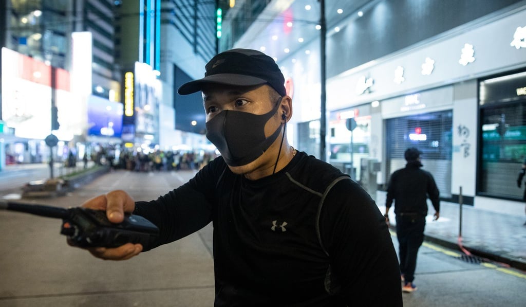 One of the men in black thought to be police. Photo: Kyle Lam/Bloomberg One of the men in black thought to be police. Photo: Kyle Lam/Bloomberg