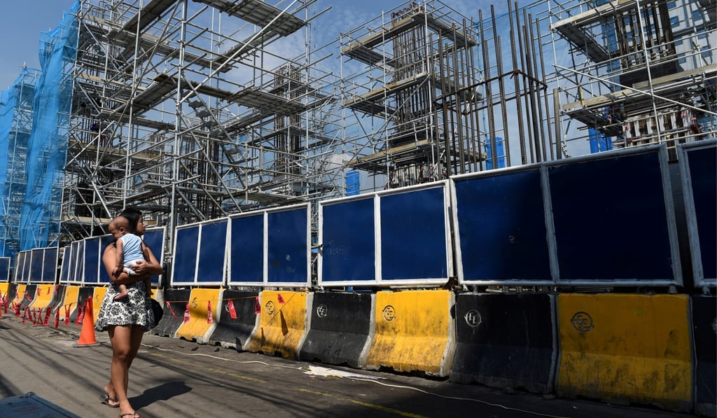 A woman passes by building works for Manila’s Metro Rail Transit system in Quezon City, in May 2018. The Duterte administration’s slogan is “Build, build, build!” Photo: Reuters A woman passes by building works for Manila’s Metro Rail Transit system in Quezon City, in May 2018. The Duterte administration’s slogan is “Build, build, build!” Photo: Reuters