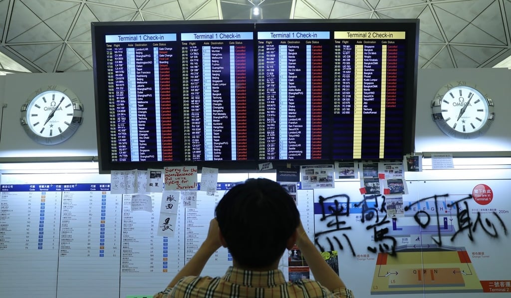 A tourist takes a photo of the electronic board showing cancelled flights at Hong Kong International Airport. Photo: Sam Tsang