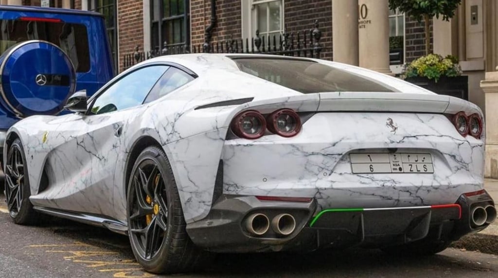 A Ferrari 812 Superfast supercar covered in vinyl printed to look like marble.