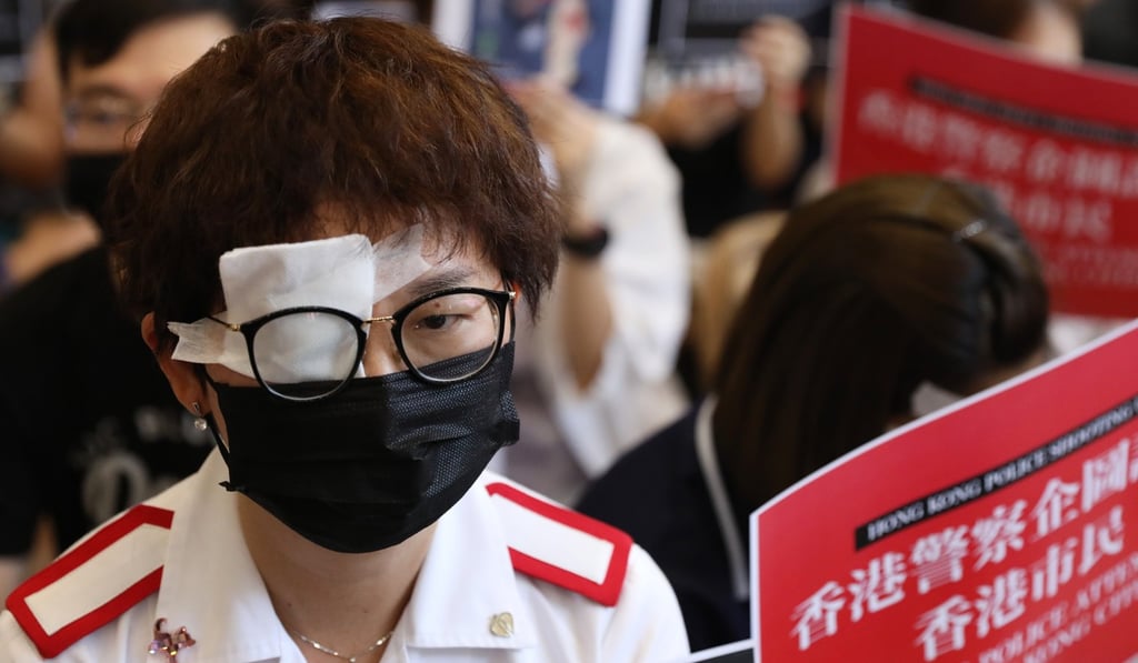 A health care provider covers her right eye with a gauze pad as a mark of protest against the right eye injury a female anti-government protester suffered in Tsim Sha Tsui last Sunday, allegedly caused by a beanbag round shot by police. Photo: Nora Tam