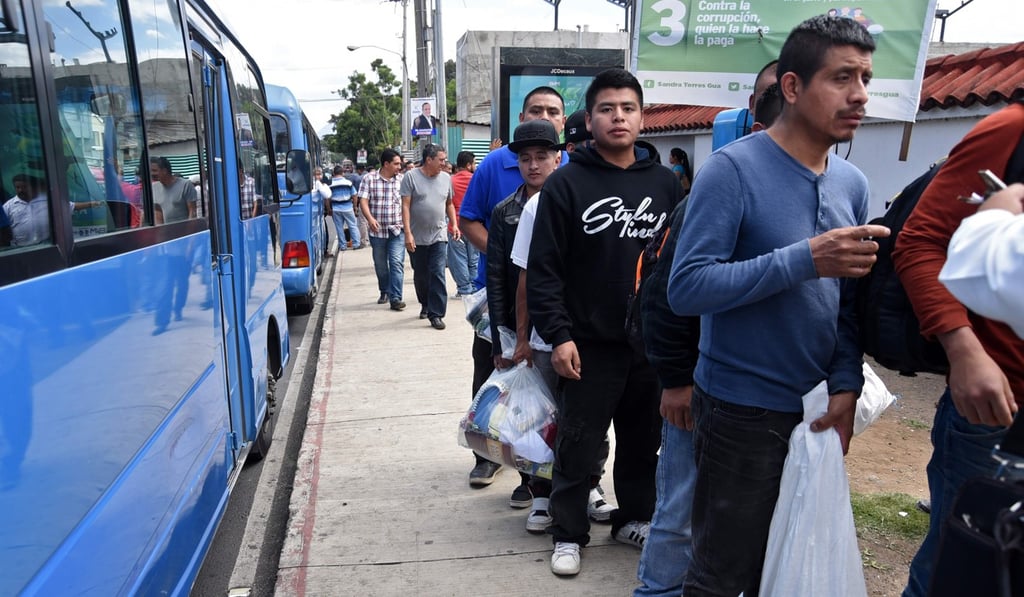 Guatemalan migrants deported from the US wait to board a bus after arriving back in the country. Photo: AFP Guatemalan migrants deported from the US wait to board a bus after arriving back in the country. Photo: AFP