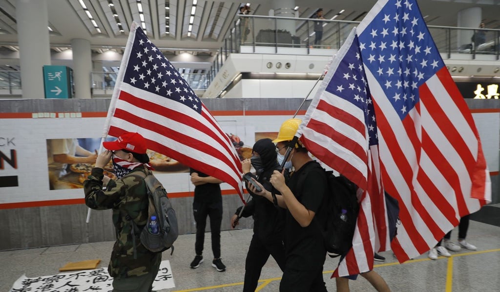 Anti-government protesters carry US flags to draw America’s attention during a demonstration at the Hong Kong International Airport on August 9. Photo: AP