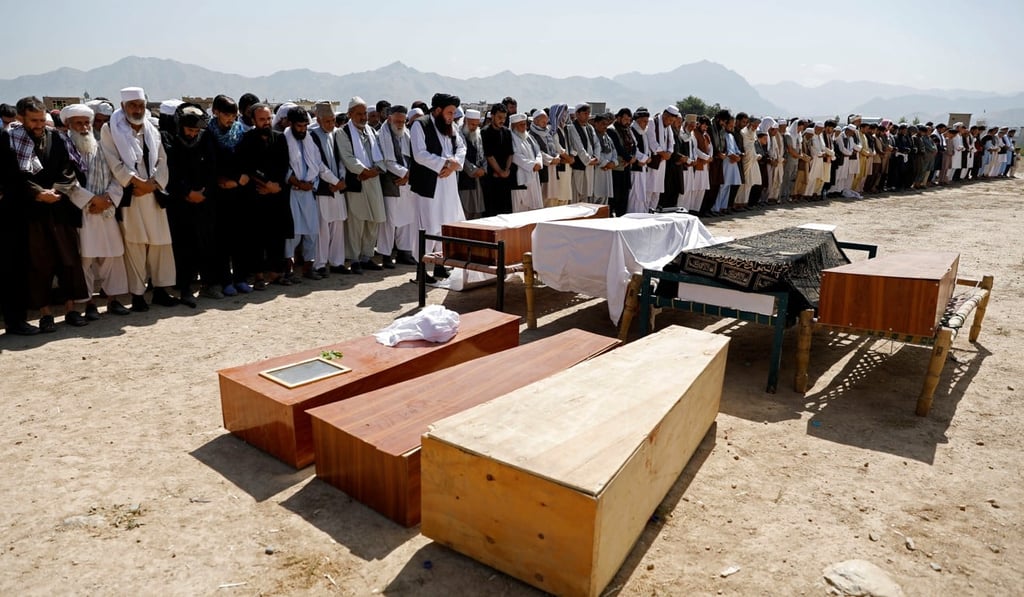 Afghan men offer funeral prayers over the coffins of the victims of the wedding blast. Photo: Reuters