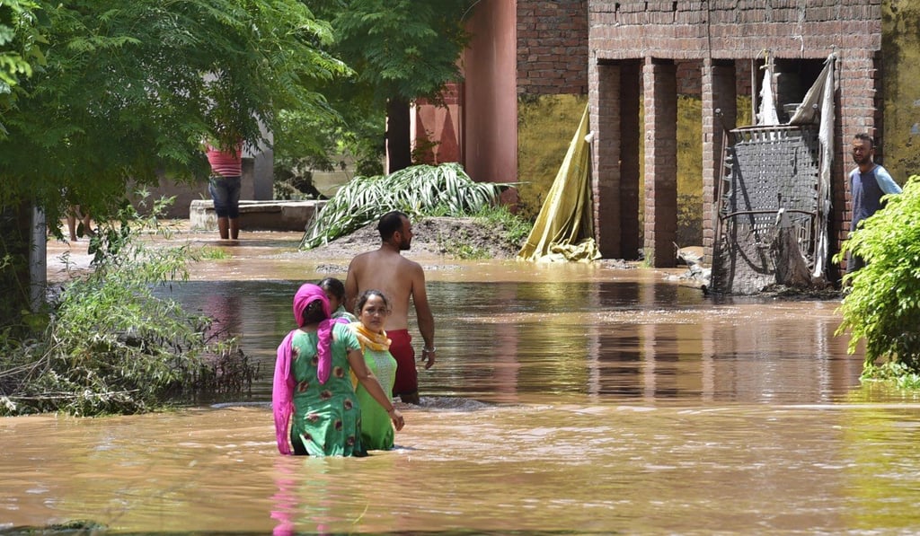 People wade through a floodwater at village Allowal in Ludhiana, India. Photo: EPA-EFE People wade through a floodwater at village Allowal in Ludhiana, India. Photo: EPA-EFE