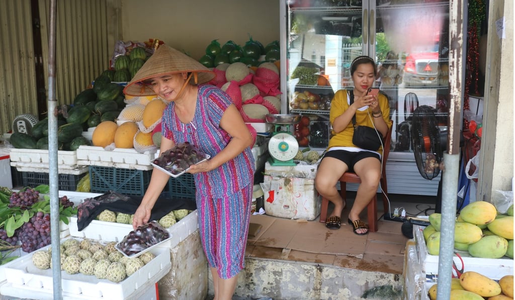 Nguyen Thi Hanh (left) buys American cherries and apples at a fruit shop in Hanoi. Photo: Bac Pham