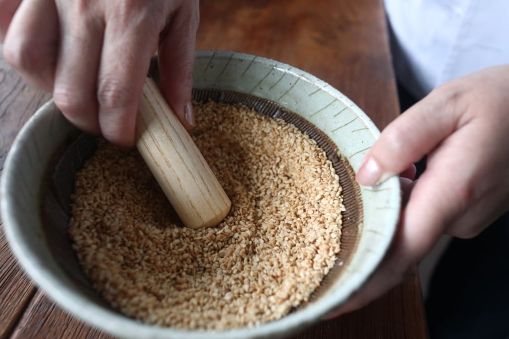 Grind the sesame seeds for the sauce. Photo: Jonathan Wong