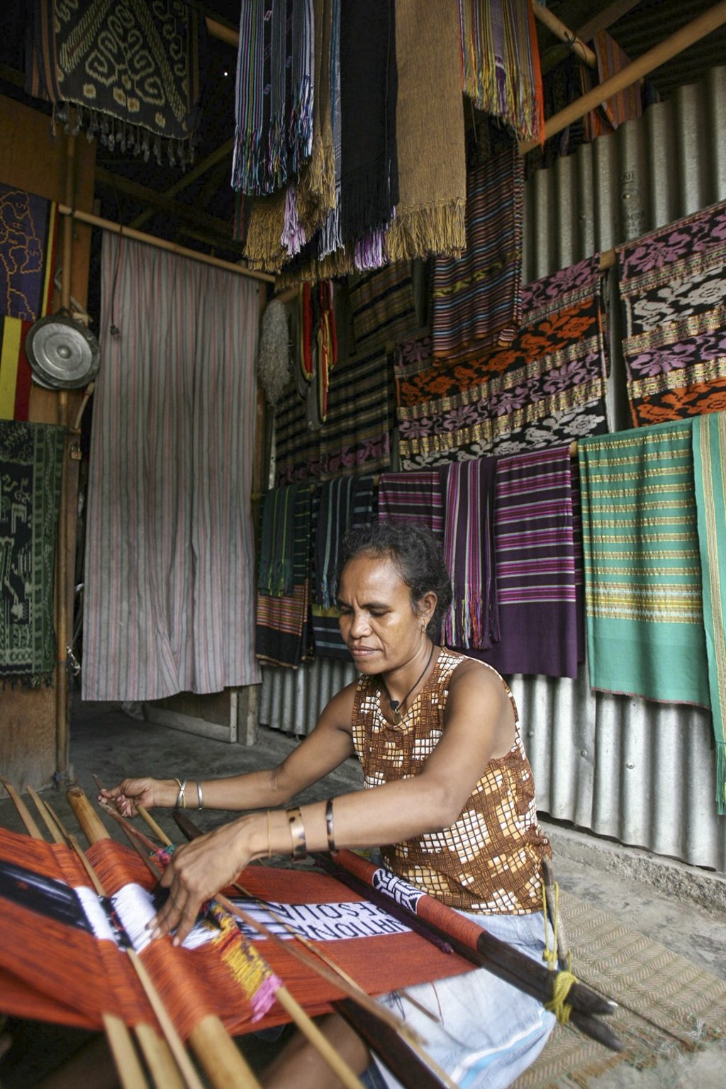 A Timorese woman weaves traditional fabric tais at a market in Dili. Photo: AFP