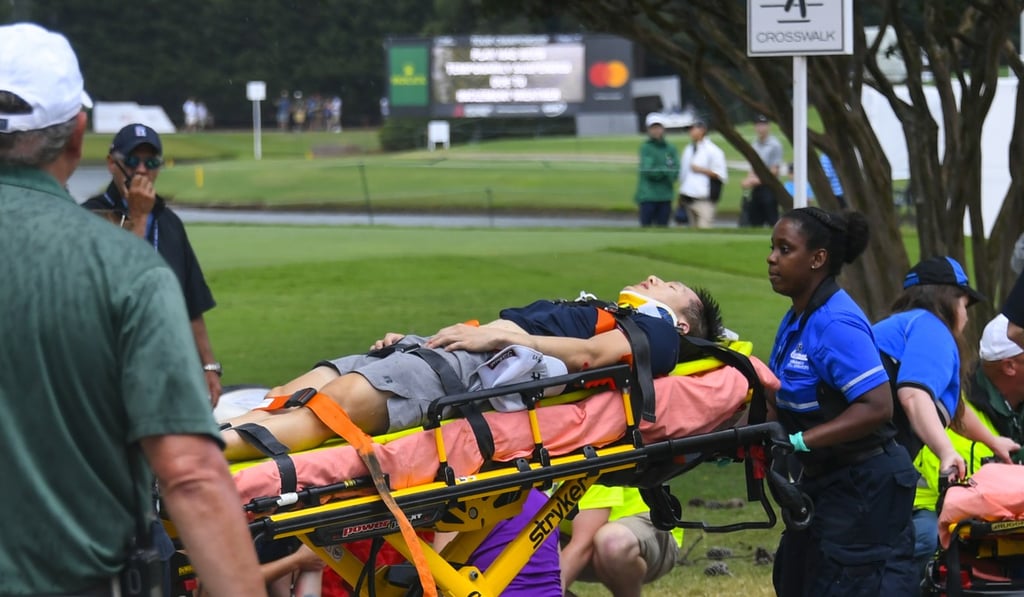 A spectator is taken to an ambulance after a lightning strike on the course. Photo: AP Photo