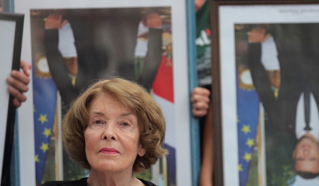 Activist Susan George is pictured with upside down official portraits of French President Emmanuel Macron. Photo: Reuters